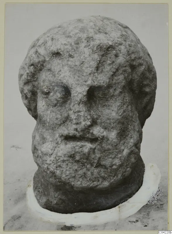 Carved stone head of a bearded man from Soli, photographed frontally against a pale background