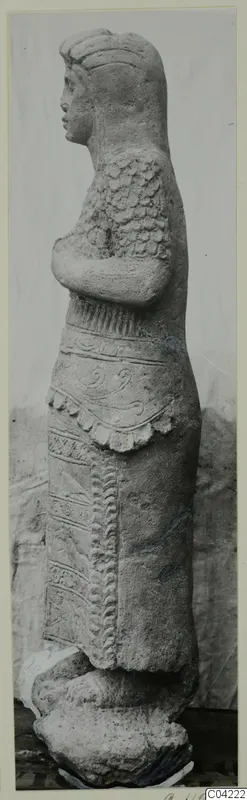 Stone statue of a standing figure in side profile with folded arms, from Soli.