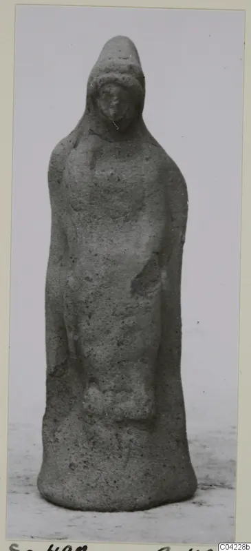 Terracotta figurine of a standing figure wearing a tall headdress, from Soli.