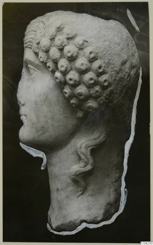 Marble head sculpture in profile facing left, with rows of rounded curls and a wavy lock falling down the neck