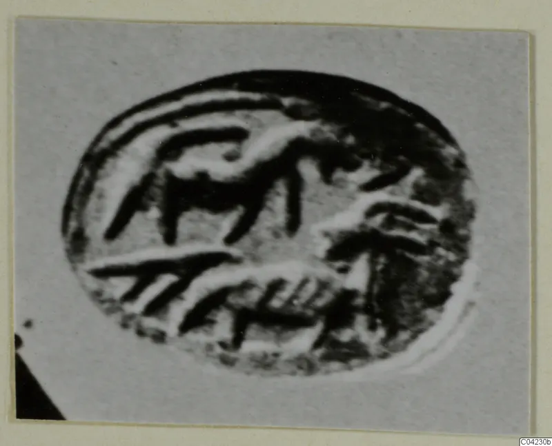 Close-up photograph of an oval engraved seal or gem with curved and straight incised strokes
