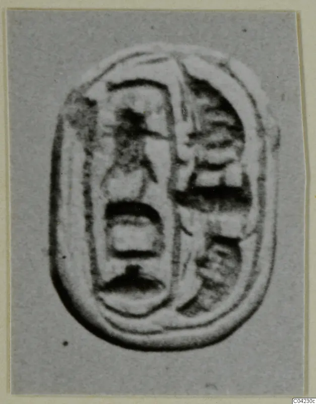 Oval seal or gem with carved signs in two vertical columns, photographed on grey card