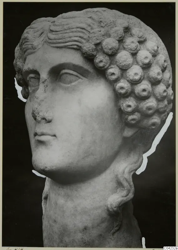 Marble head from Soli with rows of rounded curls, shown against a dark background.