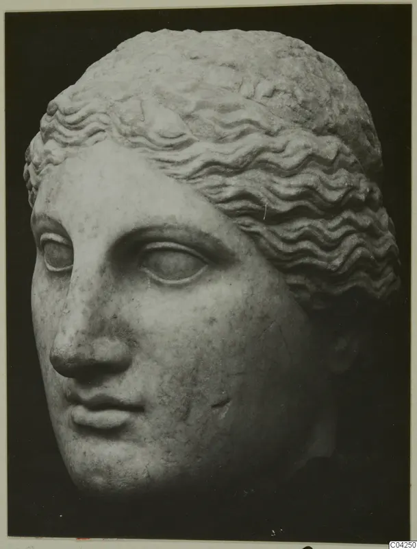 Marble head of a female figure with wavy hair, shown in three-quarter view against a dark background