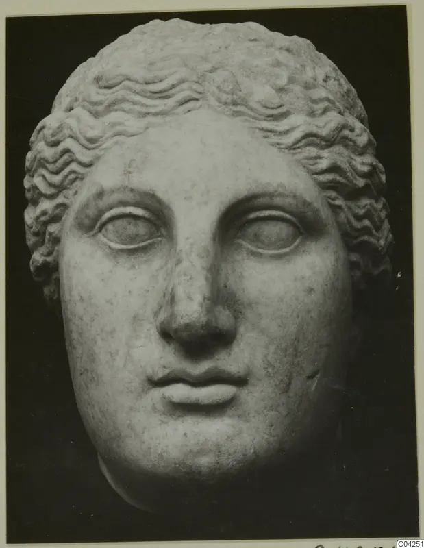 Marble head with wavy hair and large eyes, shown frontally against a dark background.