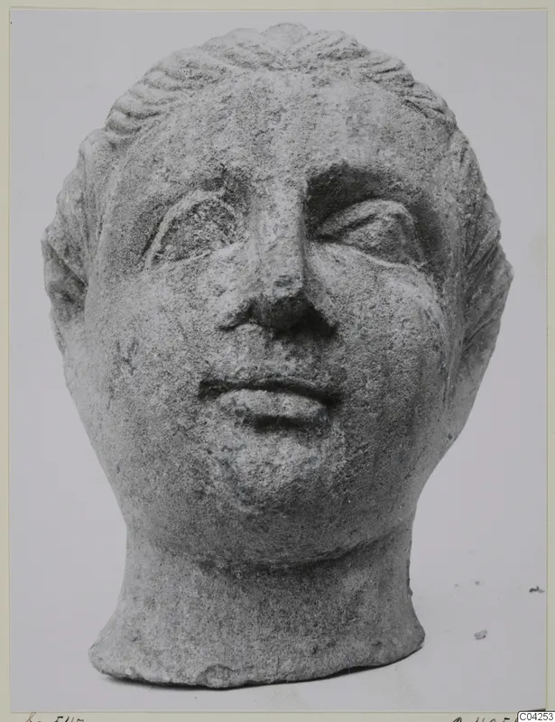 Stone head from a statuette found at Soli, with waved hair, deep-set eyes and a small mouth.