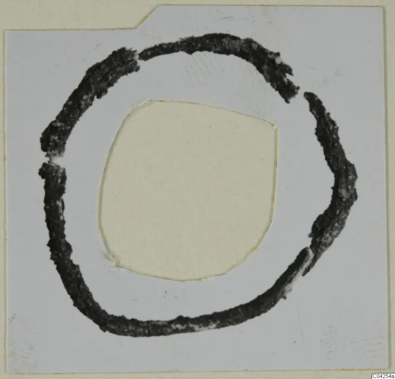 Dark ring-shaped bronze adornment on a mounted card, from Milia