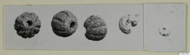 Small ribbed beads from Milia with central holes, photographed on a card mount