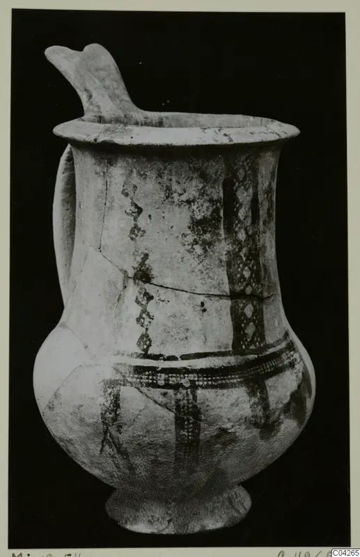 Pottery White Slip Ware jug from Milia, with a raised spout, a side handle and dark painted bands