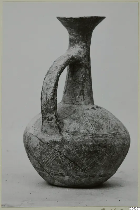Pottery jug with a single strap handle and incised chevron bands, from Milia