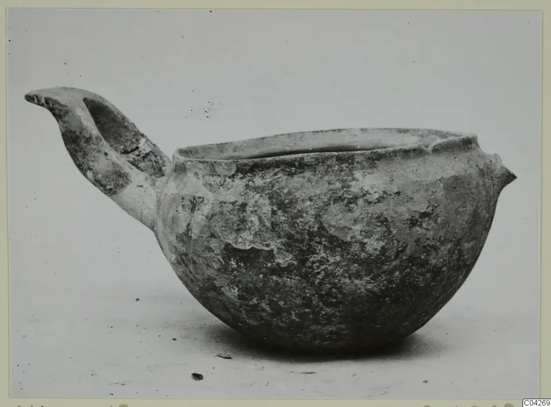 Pottery Monochrome Ware bowl from Milia with a raised handle, seen from the side