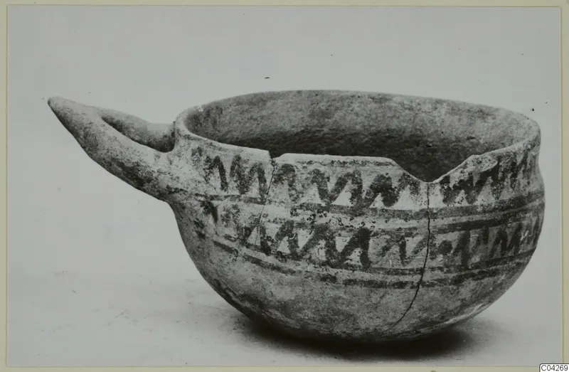 White Painted IV-V bowl from Milia with a long pointed handle and dark zigzag bands
