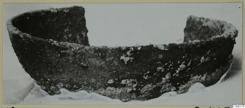 Bowl from Amathus with a dark, encrusted surface and one side broken away.