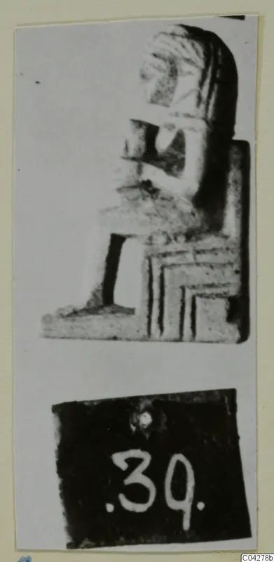 Seated figure sculpture in profile from Amathus, mounted on a card with a number label below