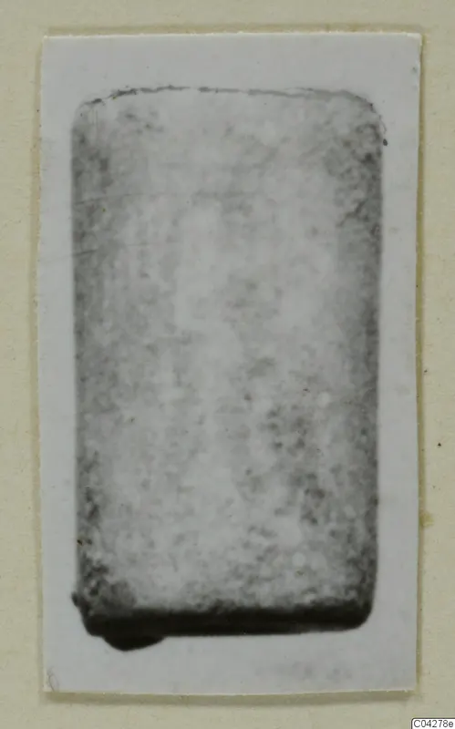 Blurred photograph of a rectangular find from Amathus, tombs 2-26, mounted on a cream card.
