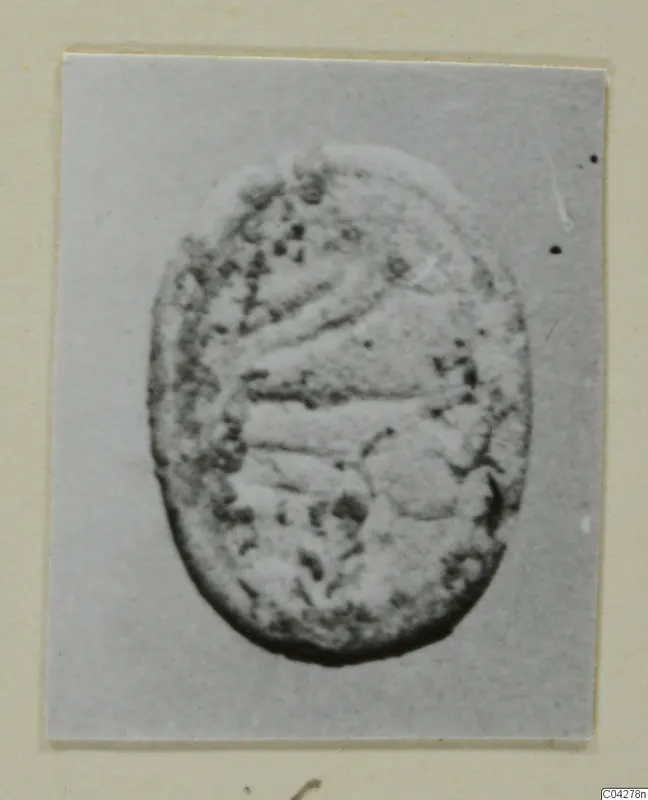 Oval seal-like object from Amathus, with curved incised lines and a dotted, worn surface