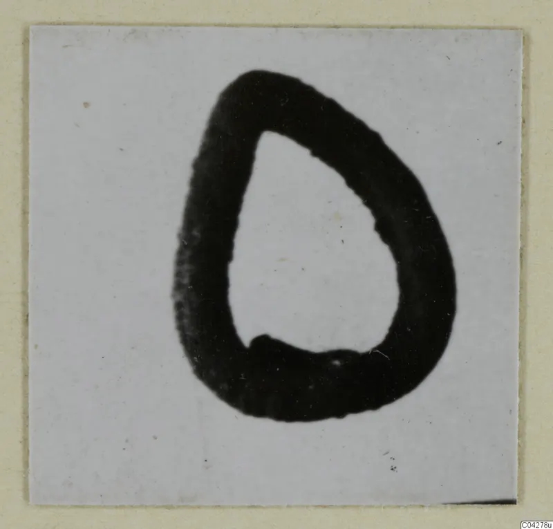 Small silver object, a thick dark loop with a teardrop outline, on a pale card mount