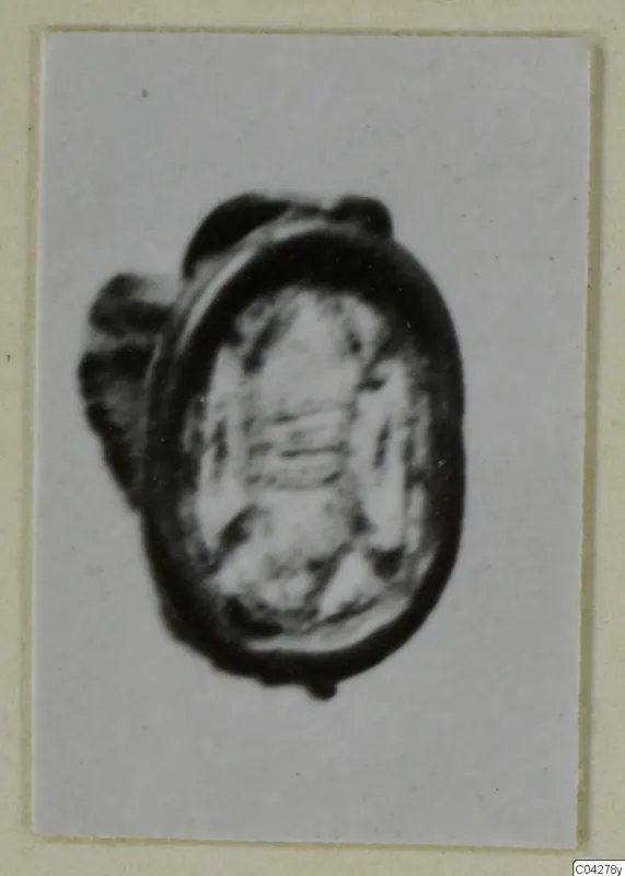 Oval glyptic seal or gem with a dark rim and a loop or mount on its left side