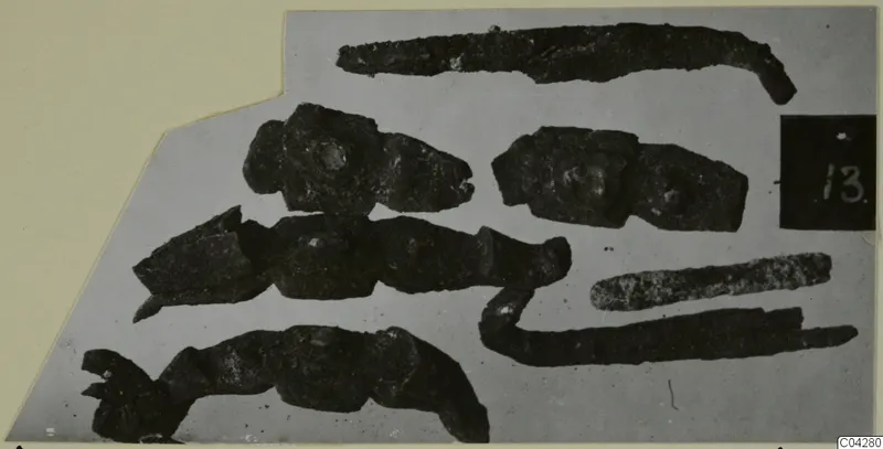 Bronze personal adornments from Amathus, corroded pieces laid out on a grey card mount.