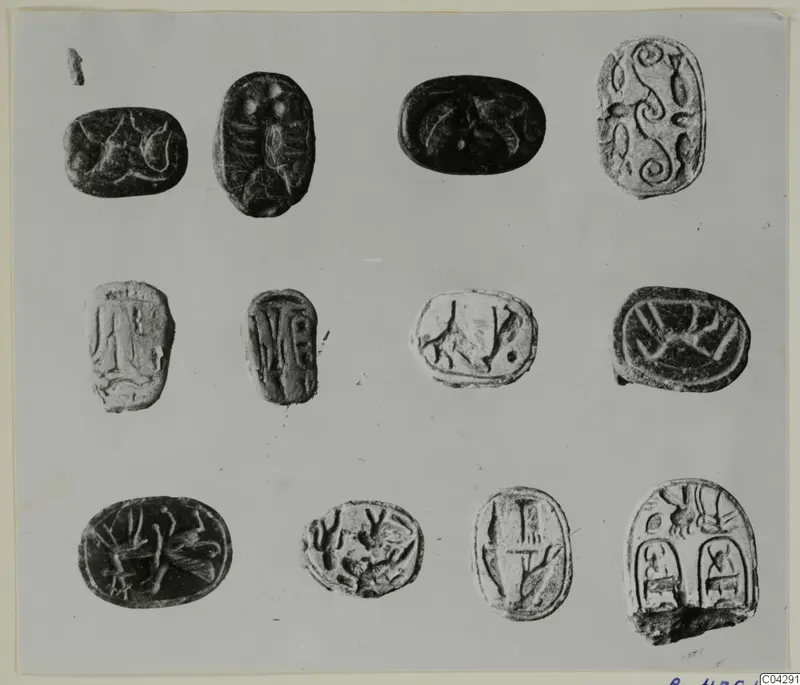 Twelve carved stone seal-shaped objects arranged in three rows, from Arsos, on a grey card