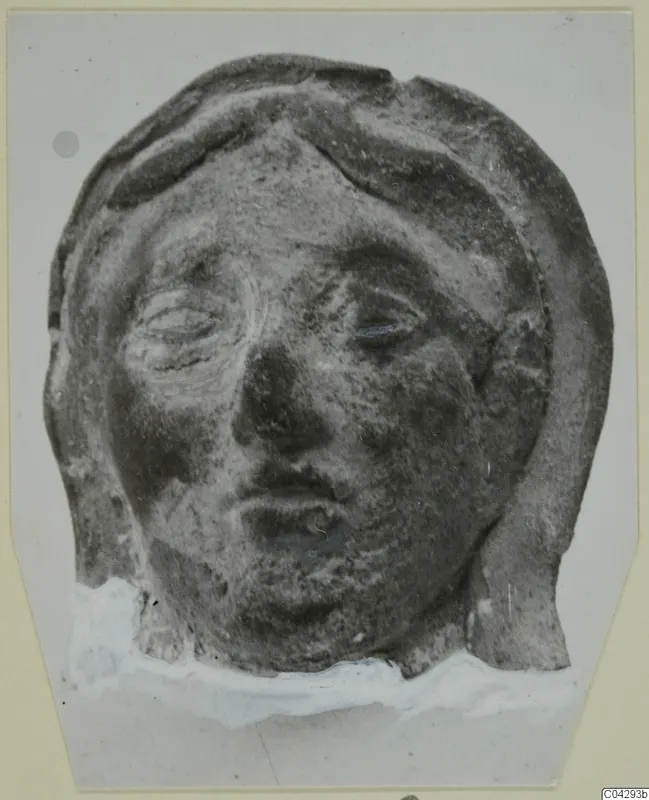 Terracotta head fragment from Marion, face framed by raised bands of hair