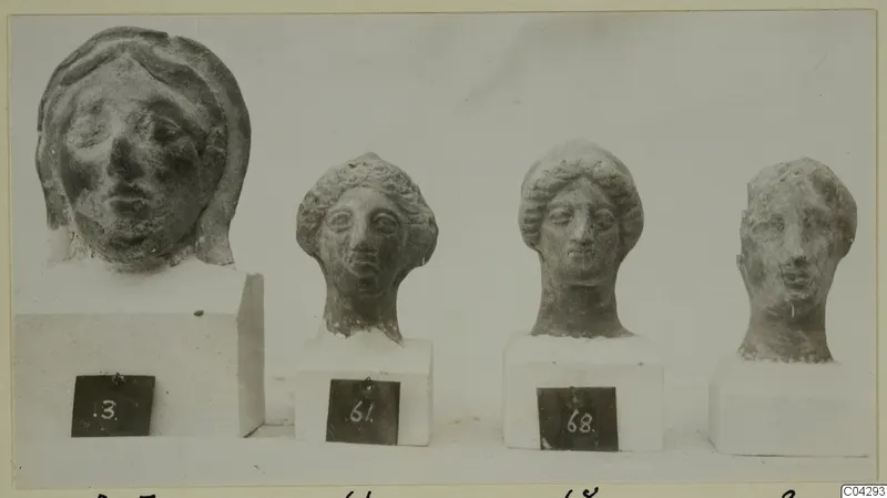 Four sculpted heads with faces on white plinths, from Marion, each with a number label.