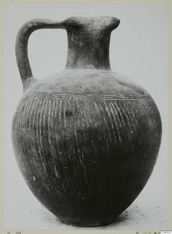 Jug with a single loop handle, tall neck and grooved globular body, recorded as Foreign Red Slip (C.M)