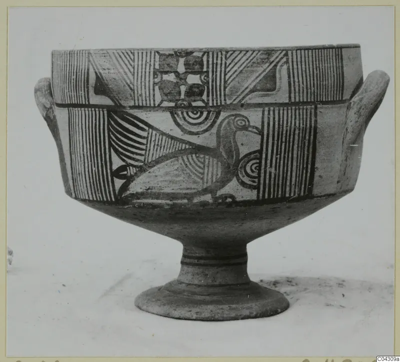 Painted pottery vessel with two small horizontal handles and a pedestal foot, decorated with stripes, circles and a bird.