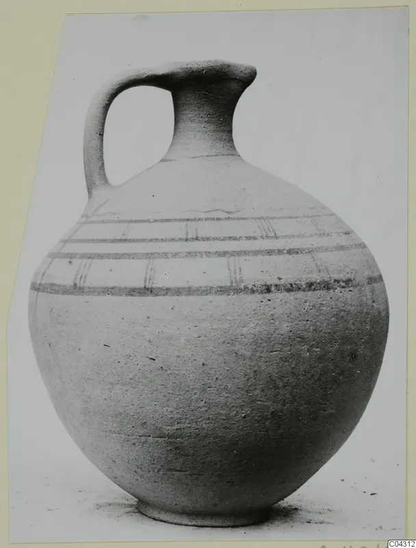Pottery juglet with a single loop handle, a tall narrow neck and horizontal painted bands on the shoulder.
