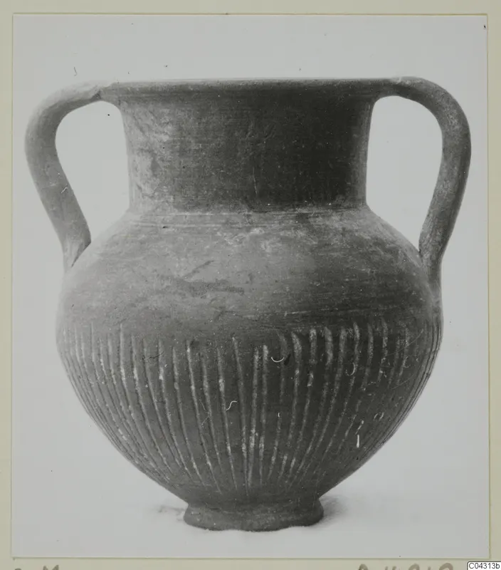Two-handled vessel with vertical fluting on the lower body, labelled Foreign Red Slip