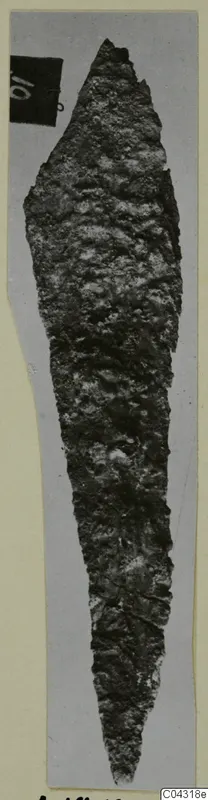 Corroded iron weapon blade with a pointed tip, photographed on grey card, from Amathus.