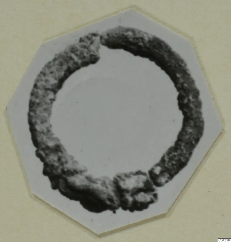 Corroded bronze ring from Amathus, broken in two places, shown on a white octagonal card.