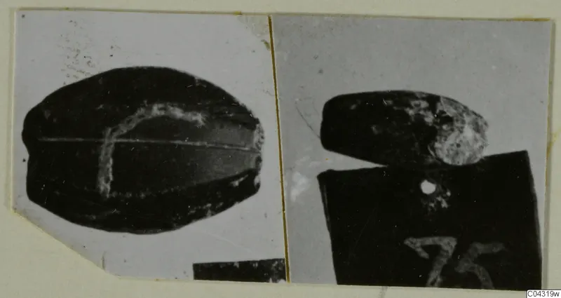 Two photographs of dark vessels from Amathus, one resting on a block with a handwritten number label