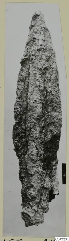 Corroded iron weapon from Amathus, a long pointed blade photographed upright against a pale background