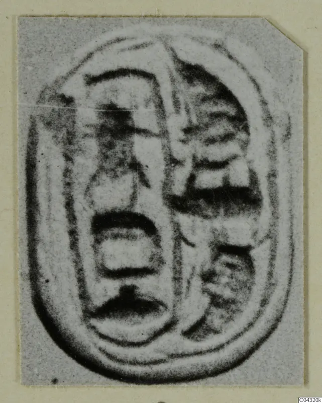 Oval engraved object from Amathus with incised signs and a raised outline, shown on a card mount