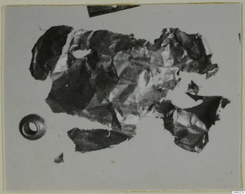 Crumpled gold jewellery fragments from Amathus, with a small hollow object at lower left.