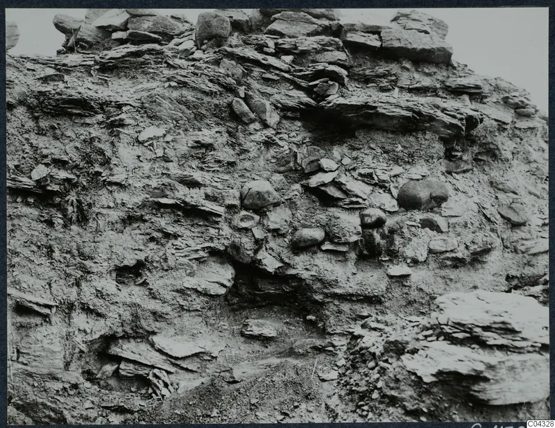 Vertical excavated section at Idalion Acropolis, with layers of flat stone slabs and rounded stones set in soil
