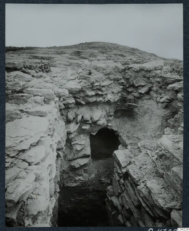 Excavation on the Acropolis at Idalion: a cut through layered pale rock leading to a dark opening
