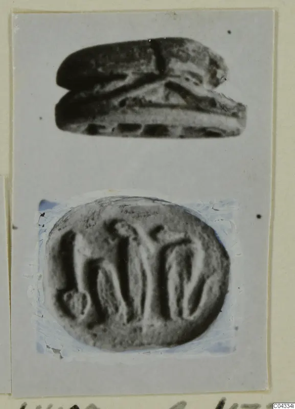 Stone scarab seal shown in side view above its engraved oval base