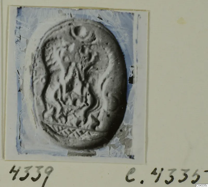 Oval seal or gem with carved wavy lines and a crosshatched band along the lower edge, shown in a photograph mounted on card.
