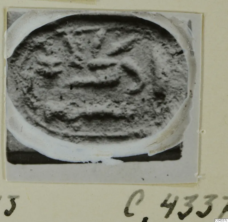 Oval seal or gem with a carved design of horizontal bands and curved strokes, pasted on an album page