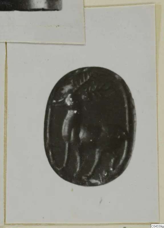 Oval dark stone gem with an engraved figure in profile, shown in a print pasted on a card mount