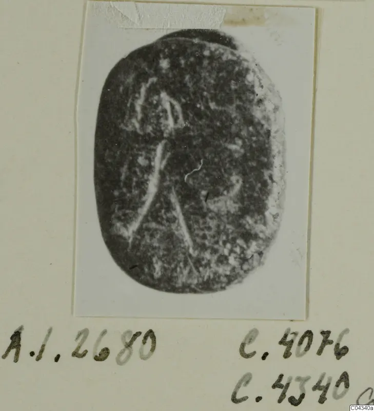 Oval dark stone seal or gem with faint pale engraved lines, shown on a mounted card