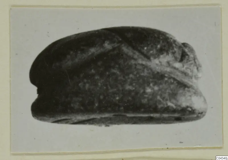 Glyptic find from Ayia Irini: a dark stone seal or gem with a domed back and a raised ridge across it.