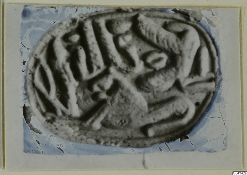 Oval stone seal or gem with carved design, photographed on a card mount