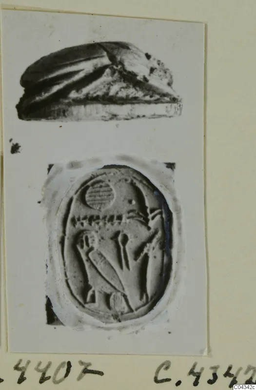 Scarab beetle and an oval seal face with carved figures, both photographed on a card mount