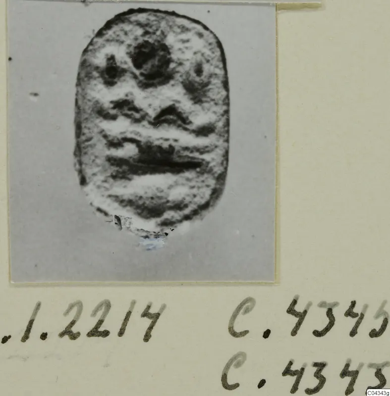 Seal or gem from Ayia Irini with a raised carved design of a face-like pattern.
