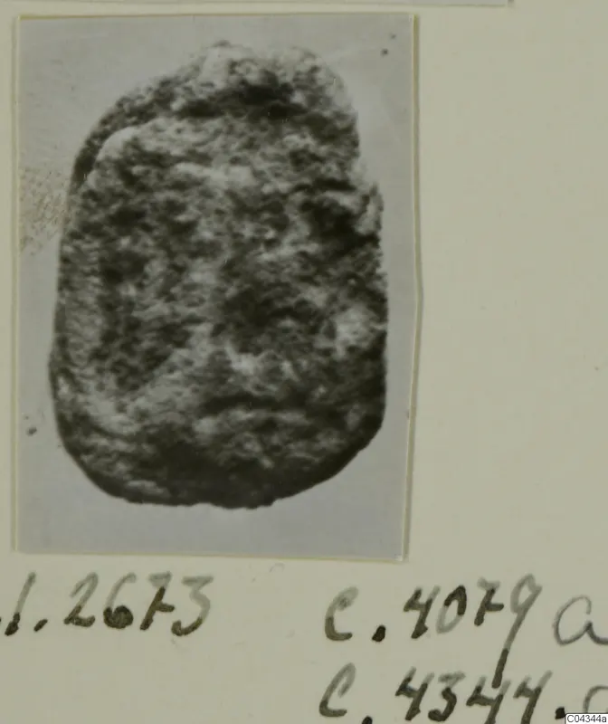 Photograph on a mount of a rounded stone object with a rough, pitted surface, handwritten numbers below
