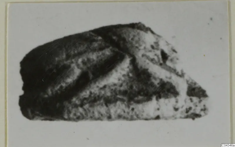 Small broken stone fragment with dark and pale bands, recorded as glyptic from Ayia Irini