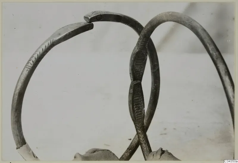 Two silver bracelets from Vouni 292, one engraved with a fine pattern, overlapping against a pale plain background